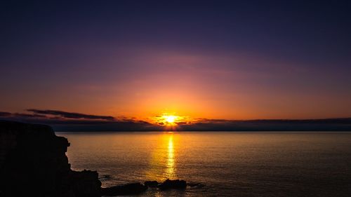 Scenic view of sea against romantic sky at sunset