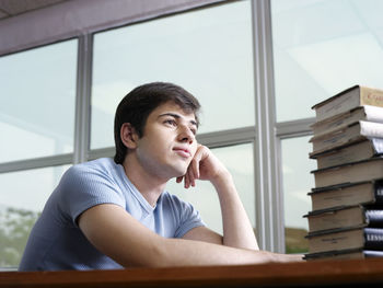 Man looking at stacked books in library