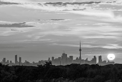 Buildings in city against cloudy sky