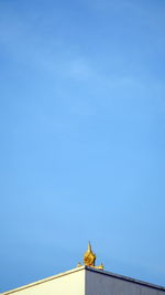Low angle view of statue against blue sky