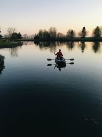 Man in kayak on lake at dusk