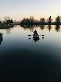 Man in boat on lake against sky