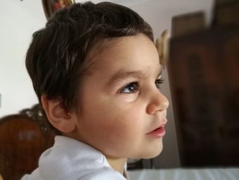 Side view of thoughtful boy looking away while sitting at home