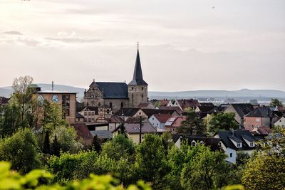 Houses and buildings in town against sky