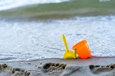 Close-up of yellow toy on beach