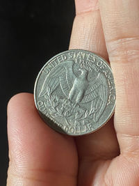 Close-up of hand holding coin