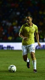 Woman playing soccer ball on grass