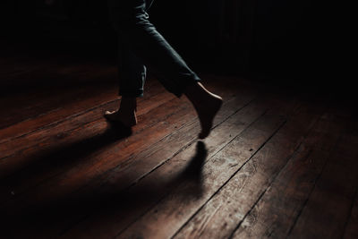 Low section of woman standing on hardwood floor