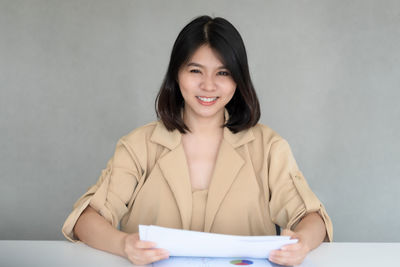 Portrait of a smiling young woman against white background