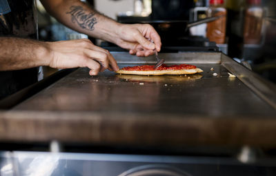 Midsection of man preparing food in kitchen