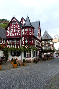 Houses by street against sky in city