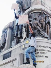 Low angle view of man holding umbrella