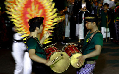 Side view of people playing in music concert