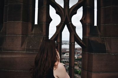 Rear view of woman standing by window at liverpool cathedral