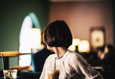 Rear view of boy sitting on table