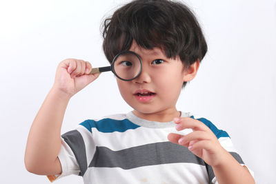 Portrait of boy holding baby against white background