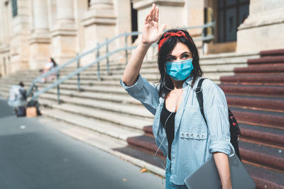 Young woman standing against buildings in city