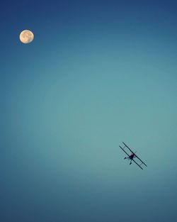 Low angle view of airplane against clear blue sky