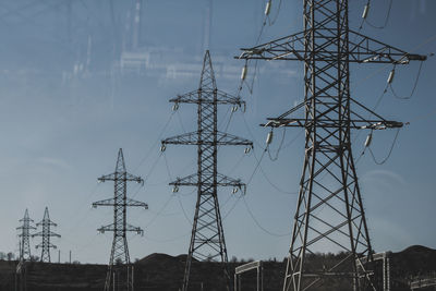 Low angle view of electricity pylon against sky