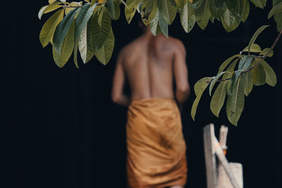 Rear view of shirtless man standing outdoors