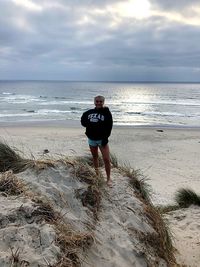 Rear view of man standing on beach