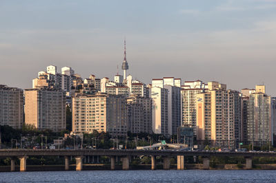 Skyscrapers in city against cloudy sky