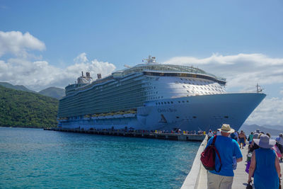 People on ship by sea against sky