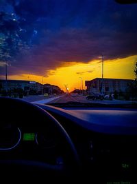 Cars on road in city during sunset