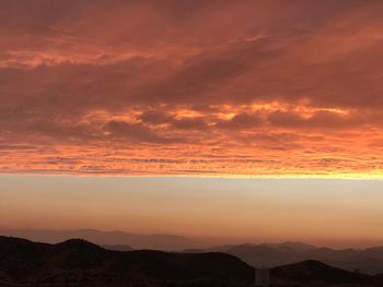 Scenic view of silhouette mountains against sky during sunset