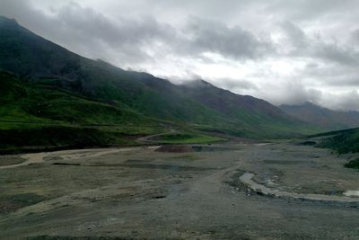 Scenic view of landscape and mountains against cloudy sky