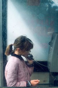 Girl standing in telephone booth