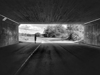 Rear view of man standing in tunnel