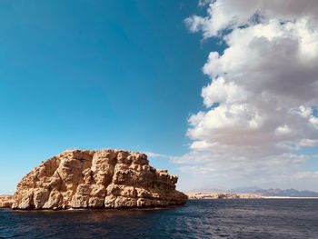 Rock formation in sea against sky