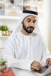 Young man using mobile phone on table