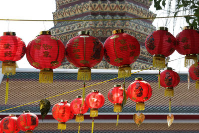 Chinese lanterns hanging by temple against sky