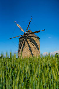 Traditional windmill on field against sky