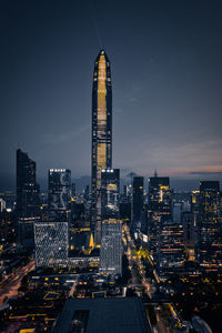 Illuminated buildings in city against sky at night