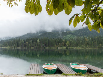 Boats moored in lake against sky