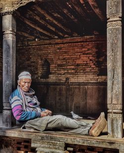 Portrait of man sitting on wall