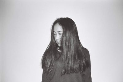 Portrait of beautiful young woman against white background