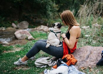 Man with dog sitting on rock