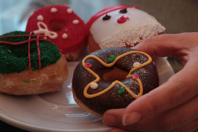 Cropped hand of person holding donuts 