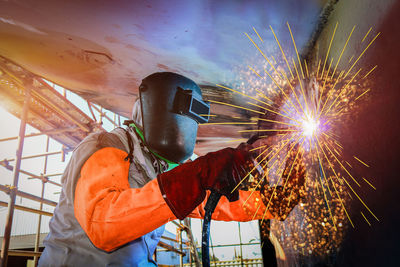 Man working on illuminated metal structure