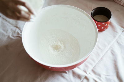 High angle view of hand holding bowl on table