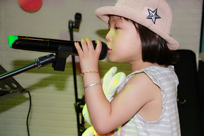 Close-up of cute girl singing with microphone