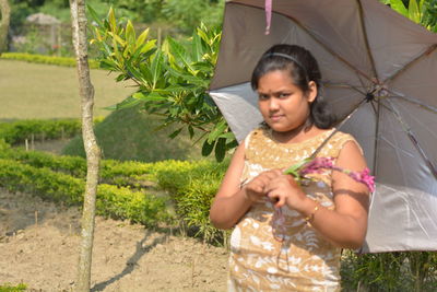 Young woman looking away while standing on land