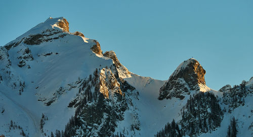 Low angle view of snowcapped mountain against blue sky