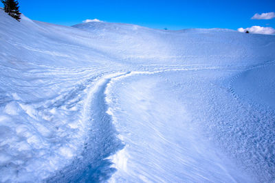 Scenic view of snowcapped mountains against blue sky