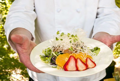 Close-up of man holding ice cream in plate