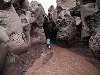 Rear view of woman exploring rock formation